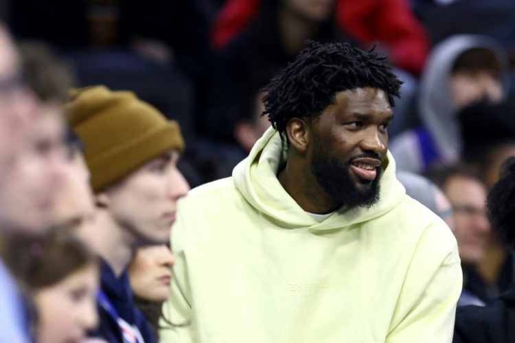 Reigning NBA MVP Joel Embiid of the Philadelphia 76ers watches from the sidelines after a knee injury but says he plans to return this season, if his body cooperates. ©AFP