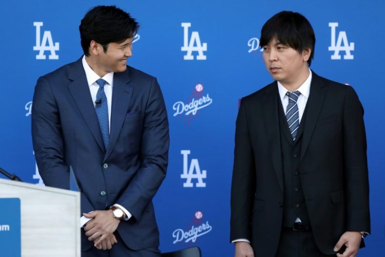 Shohei Ohtani, left, speaks with interpreter Ippei Mizuhara prior to being introduced by the Los Angeles Dodgers at Dodger Stadium in December 2023. ©AFP