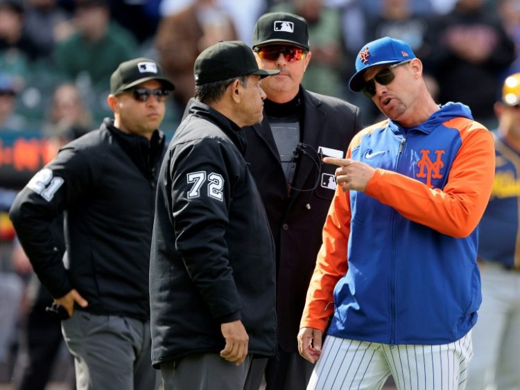 New York Mets manager Carlos Mendoza, right, argues with umpire Alfonso Marquez after Mets pitcher Yohan Ramírez was ejected for throwing at Milwaukee's Rhys Hoskins, actions that led to a three-game MLB suspension for Ramirez and a one-game ban for Marquez. ©AFP