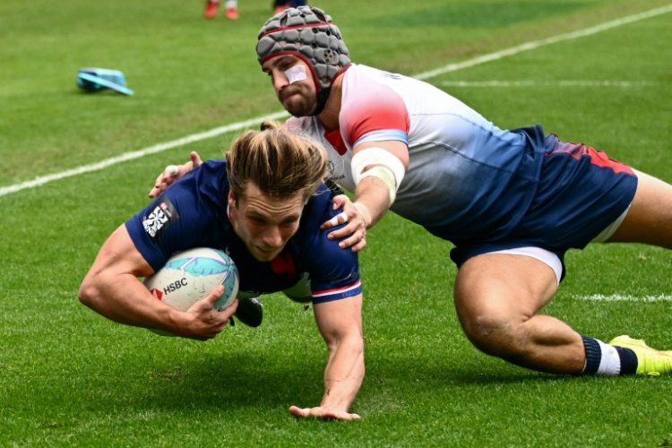 France's Stephen Parez-Edo Martin dives past Great Britain's Ethan Waddleton to score a try in France's victory over the British at the Los Angeles Rugby Sevens tournament. ©AFP