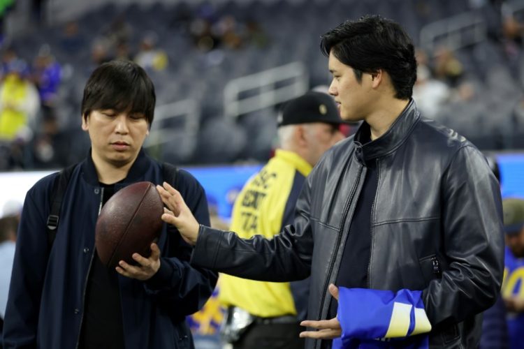 Baseball star Shohei Ohtani talks with his interpreter Ippei Mizuhara before an NFL football game between the New Orleans Saints and the Los Angeles Rams at SoFi Stadium. ©AFP