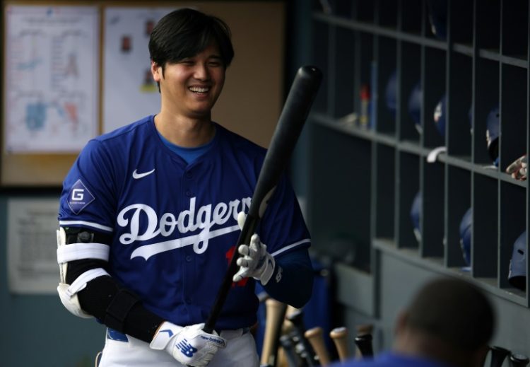 Los Angeles Dodgers superstar Shohei Ohtani of Japan smiles as he warms up for an exhibition game against the Los Angeles Angels at Dodger Stadium. ©AFP