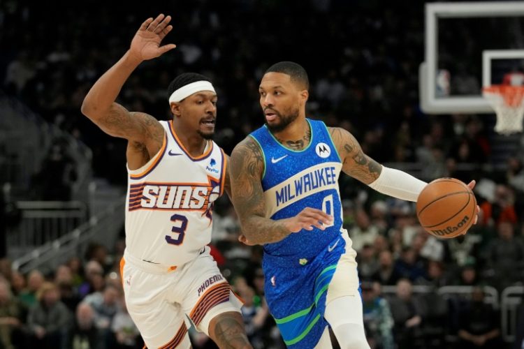 Milwaukee's Damian Lillard, at right driving against Phoenix's Bradley Beal, scored 31 points and added 16 assists in a 140-129 NBA victory over the visiting Suns. ©AFP