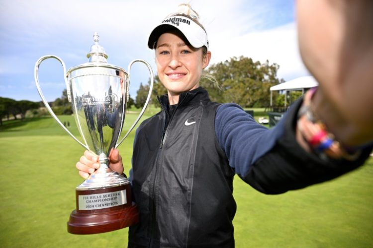 Nelly Korda imitates a "selfie" while holding her trophy from last week's LPGA event, a victory that restored her to the world number one ranking. ©AFP