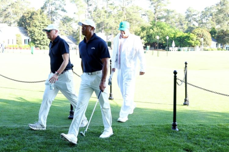 Tiger Woods, center, heads for the Augusta National clubhouse after a Masters practice round on Monday morning at Augusta National alongside Rob McNamara, left, and Woods caddie Lance Bennett, right. ©AFP