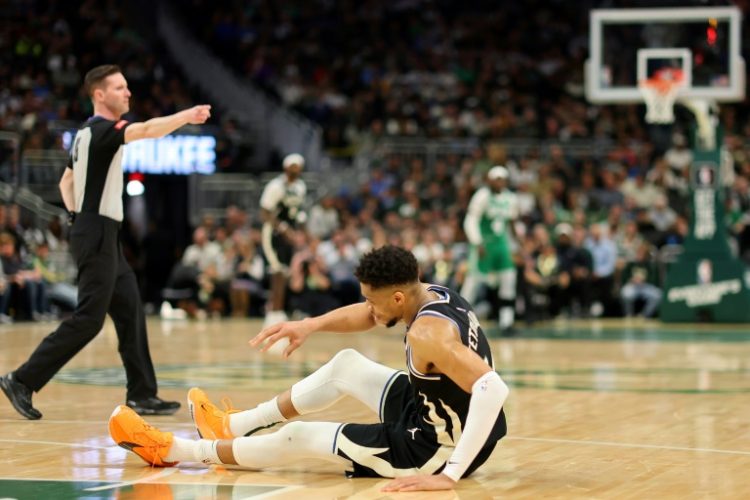 Down and out: Milwaukee star Giannis Antetokounmpo tumbles to the floor after suffering a non-contact calf injury in his team's win over Boston . ©AFP