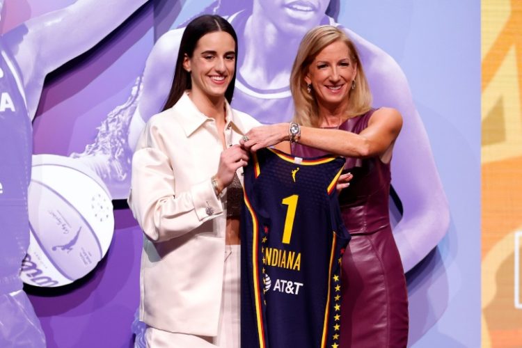 Caitlin Clark poses with WNBA Commissioner Cathy Engelbert after being selected first overall by the Indiana Fever in the 2024 WNBA draft. ©AFP