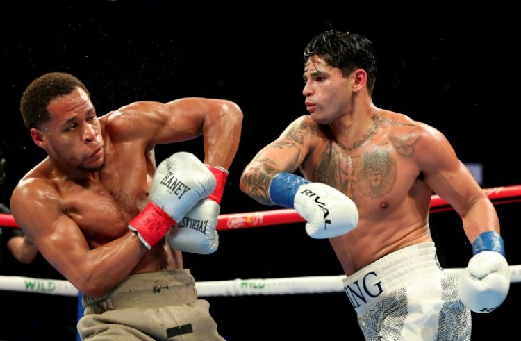 Ryan Garcia (white trunks) punches Devin Haney (gray trunks) on the way to a majority decision victory in their super-lightweight bout in Brooklyn, New York. ©AFP