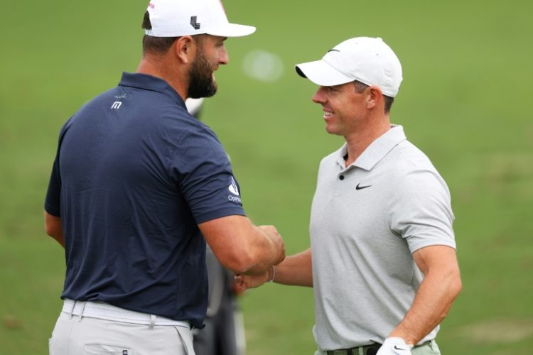 Defending champion Jon Rahm of Spain, left, greets world number two Rory McIlroy of Northern Ireland in the practice area ahead of Thursday's start of the 88th Masters. ©AFP