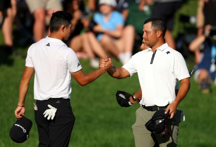 Americans Collin Morikawa, left, and Xander Schauffele shake hands on the 18th green at Valhalla after sharing the lead through three rounds of the PGA Championship . ©AFP