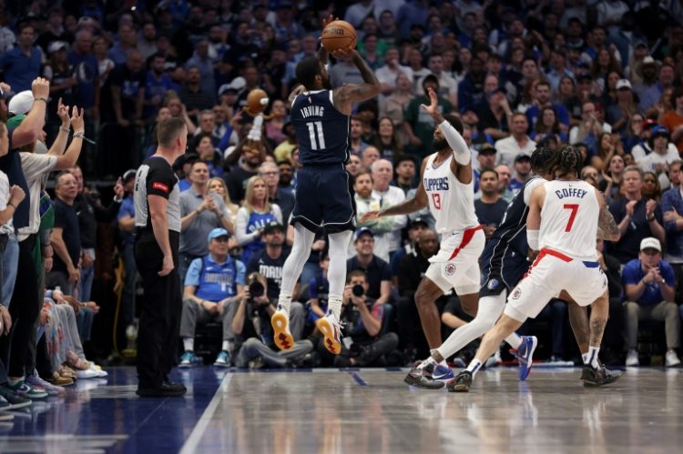Kyrie Irving of the Dallas Mavericks takes a three-point shot over Paul George in the Mavericks' series-clinching victory over the Los Angeles Clippers in game six of their NBA Western Conference first-round playoff series. ©AFP