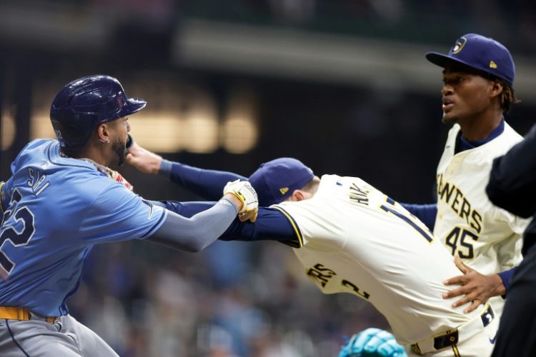 Rhys Hoskins of the Milwaukee Brewers holds back Jose Siri of the Tampa Bay Rays who attempts to go after Brewers pitcher Abner Uribe in a Major League Baseball game that saw three players and the Brewers' manager ejected. ©AFP