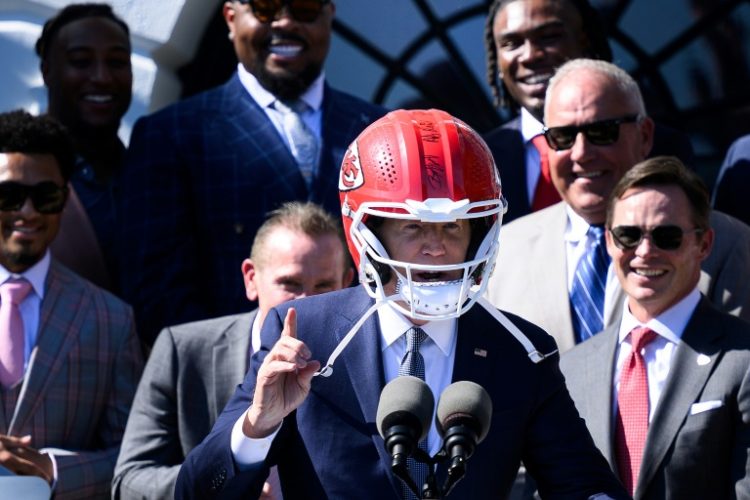 US President Joe Biden wears a Kansas City Chiefs helmet while speaking during a celebration for the Kansas City Chiefs, 2024 Super Bowl champions, on the South Lawn of the White House in Washington, DC, on May 31, 2024.. ©AFP