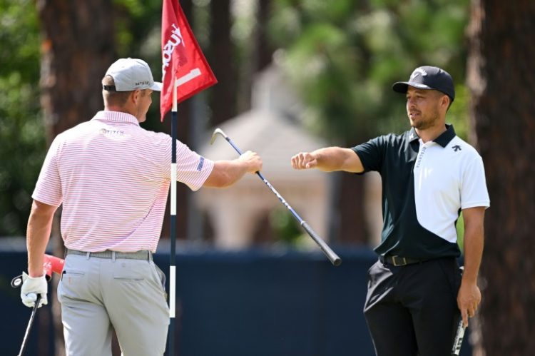 Bryson DeChambeau, left, shares a fist bump on the first tee at Pinehurst with fellow American Xander Schauffele, who edged him for last month's PGA Championship victory at Valhalla. ©AFP