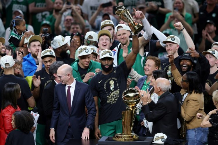 Jaylen Brown of the Boston Celtics holds up the Bill Russell NBA Finals Most Valuable Player award after the Celtics' title-clinching victory over the Dallas Mavericks. ©AFP