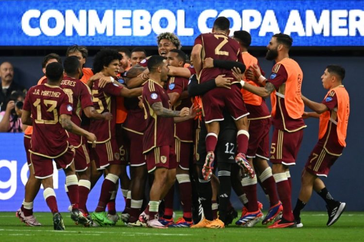 Venezuela's players mob goalscorer Salomon Rondon after his decisive penalty in the 1-0 win over Mexico. ©AFP
