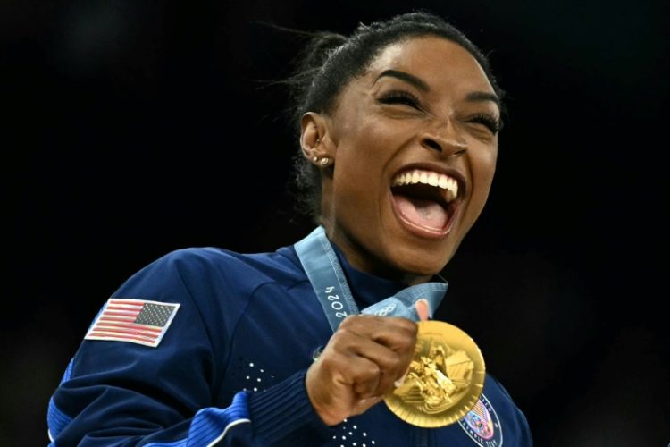 Golden again: Simone Biles poses with the gold medal after leading the United States to victory in the women's gymnastics team final at the Paris Olympics. ©AFP