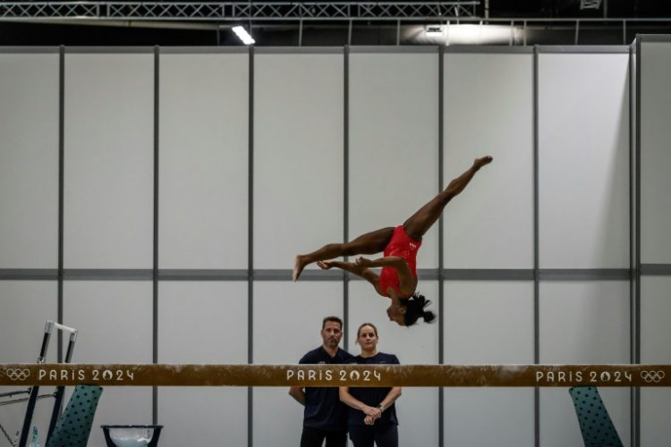 Coaches Laurent and Cecile Landi watch as superstar US gymnast Simone Biles trains at the Paris Olympics. ©AFP