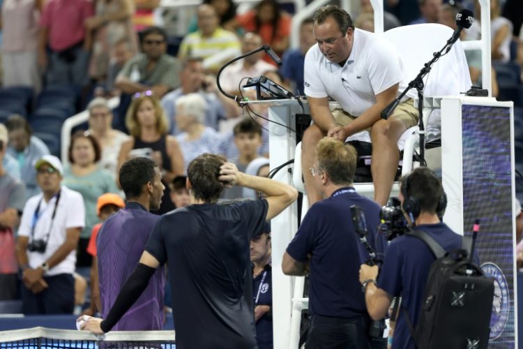 Chair umpire Greg Allensworth explains a controversial match-ending point to Canada's Felix Auger-Aliassime, lower left, and Britain's Jack Draper, who won to reach the ATP Cincinnati Open quarter-finals. ©AFP