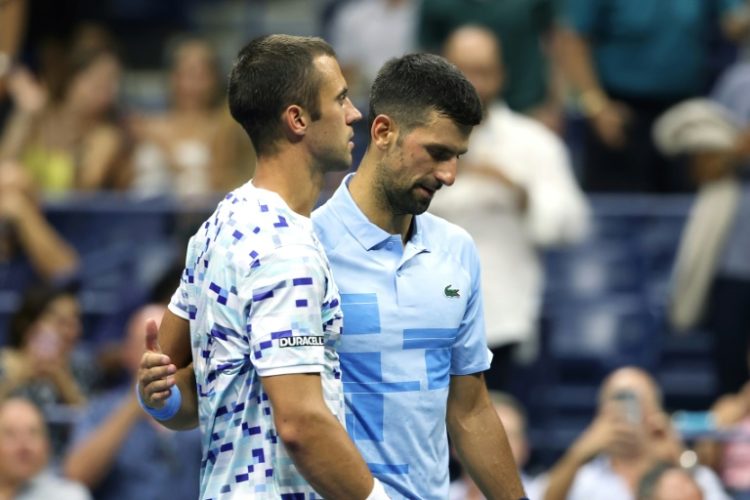 Painful end: Laslo Djere is consoled by  Novak Djokovic after being forced to retire from their second round match. ©AFP