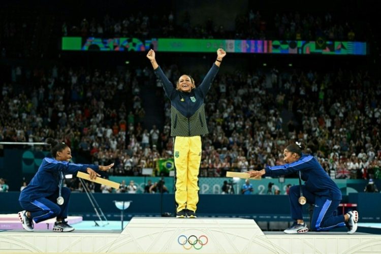 US gymnastics great Simone Biles (L) and teammate Jordan Chiles (R) bow to Brazil's Rebeca Andrade who took Olympic gymnastics floor gold in Paris. ©AFP