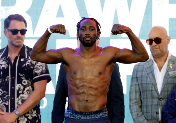 Terence Crawford, flexing his muscles at a pre-fight weigh-in, won the WBA super-welterweight crown by winning a unanimous decision over Ismail Madrimov. ©AFP