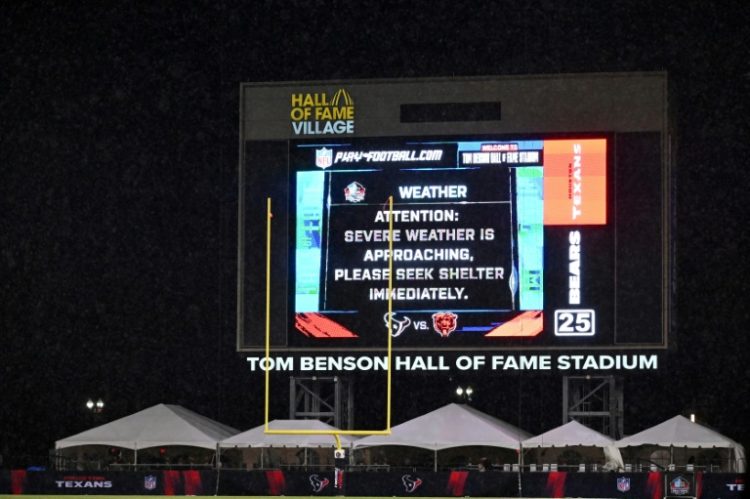 The scoreboard at the NFL's first pre-season game between Houston and Chicago warns of the storm that eventually halted the game in the third quarter, leaving Chicago a 21-17 winner. ©AFP