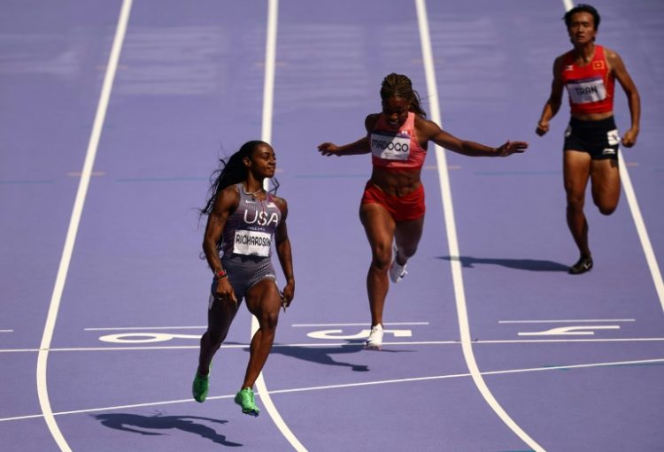 Sha'Carri Richardson (left) cruises to victory in the opening heat of the women's 100m at the Olympics on Friday. ©AFP