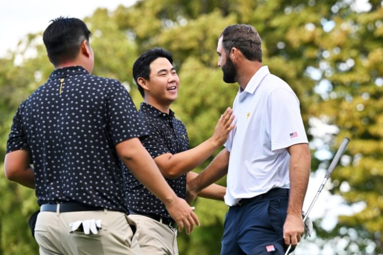 US star Scottie Scheffler, right, shakes hands with pal Tom Kim of South Korea after a US victory in a match that saw the friends trade verbal jibes after long birdie putts. ©AFP