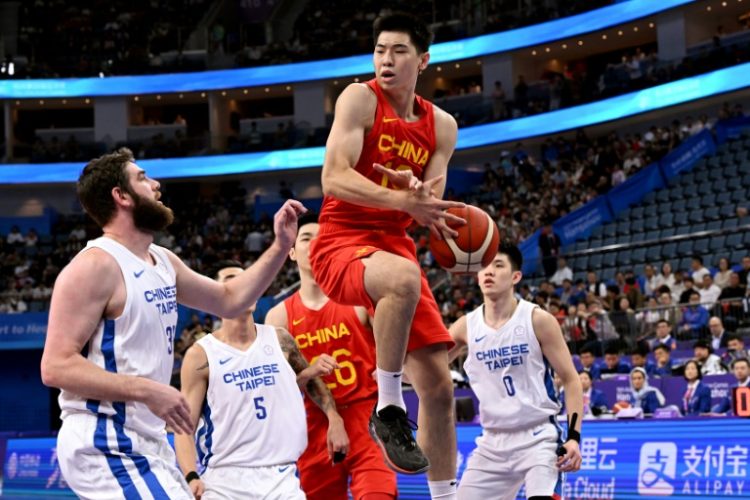 China's Cui Yongxi, shown at center grabbing a rebound in the 2022 Asian Games, has signed a contract with the NBA Brooklyn Nets. ©AFP