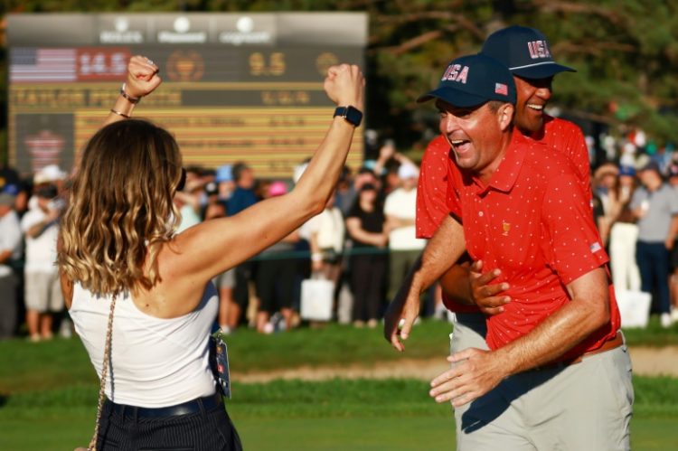 Keegan Bradley, right, celebrates with wife Jillian, left, after taking a trophy-clinching 1-up victory at the Presidents Cup. ©AFP