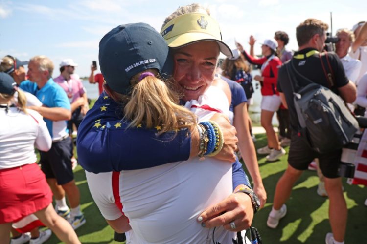 Europe captain Suzann Pettersen, facing front, hugs US captain Stacy Lewis after the Americans beat Europe to win the Solheim Cup. ©AFP