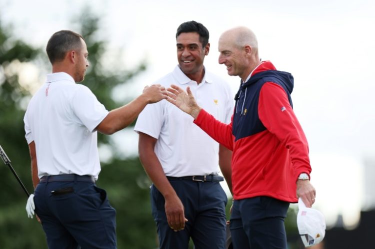 Second-ranked Xander Schauffele, left, and partner Tony Finau, center, celebrate with US captain Jim Furyk as the USA took a 5-0 lead over the Internationals after day one of the Presidents Cup. ©AFP