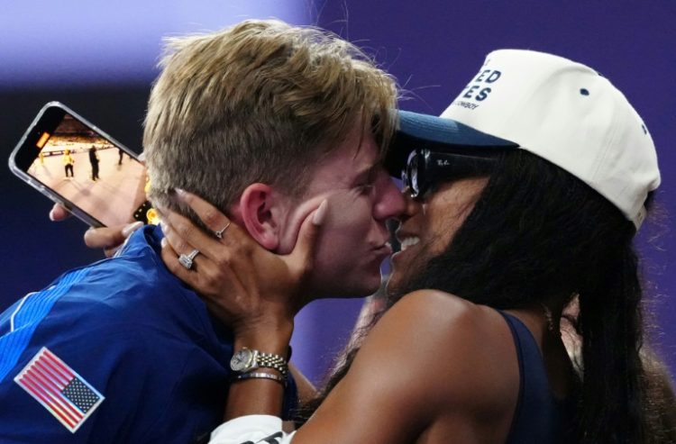 Hunter Woodhall gets a kiss from with his wife, Olympic women's long jump champion Tara Davis-Woodhall, after he received his Paralympic T62 gold medal. ©AFP