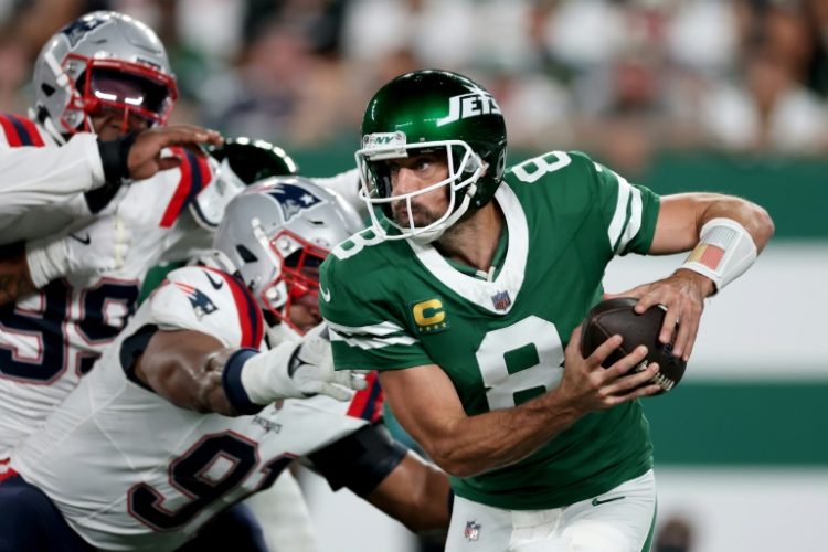 New York Jets quarterback Aaron Rodgers scrambles in an NFL victory over the New England Patriots. ©AFP