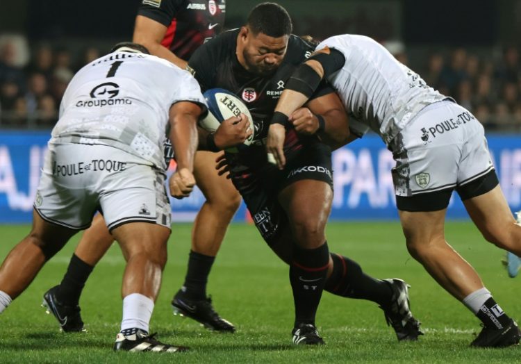 Toulouse' prop Rodrigue Neti (C) is tackled by Vannes' Mako Vunipola (L) . ©AFP