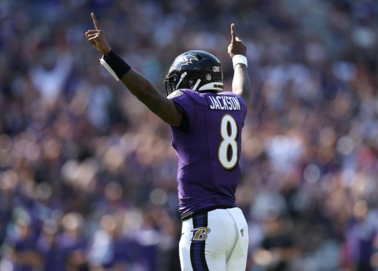 Lamar Jackson celebrates a Derrick Henry touchdown run as the Baltimore Ravens beat Washington in an NFL game. ©AFP