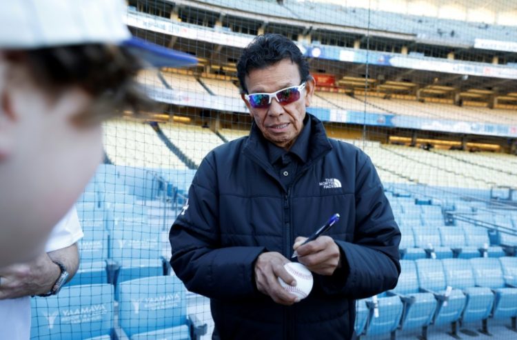 Former Los Angeles Dodgers pitching great Fernando Valenzuela autographs a ball for fans before a game in April 2024. ©AFP