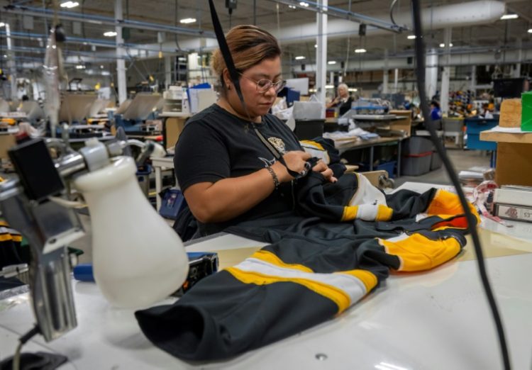 An employee works on a jersey at SP Apparel in Saint-Hyacinthe, Quebec; the Canadian firm makes jerseys for all 32 NHL teams . ©AFP