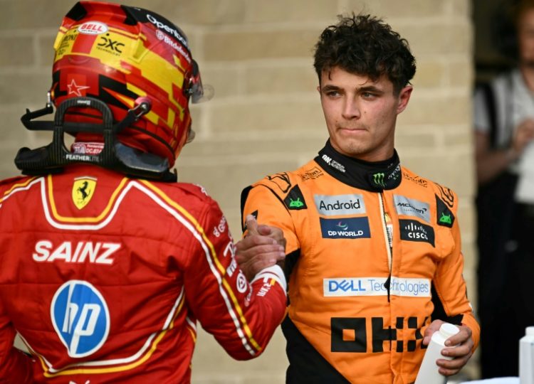 McLaren driver Lando Norris shakes hands with Ferrari's Carlos Sainz  after winning the pole position for the United States Grand Prix. ©AFP