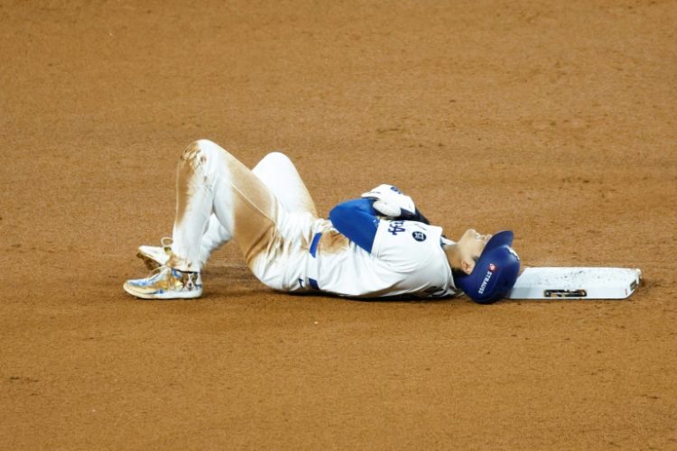 Los Angeles Dodgers star Shohei Ohtani lies on the ground after injuring his shoulder attempting to steal second base in the Dodgers' World Series game two victory over the New York Yankees. ©AFP