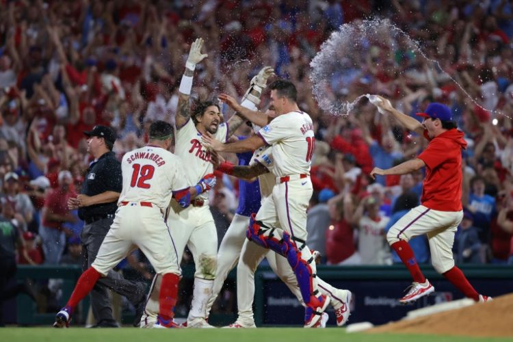 Nick Castellanos (center) celebrates with team-mates after driving in the winning run in the Philadelphia Phillies' 7-6 playoff win over the New York Mets. ©AFP