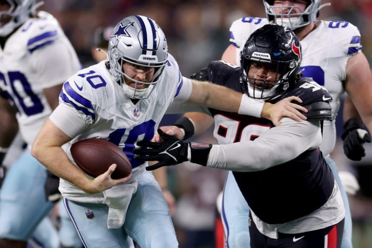 Under pressure: Dallas Cowboys reserve quarterback Cooper Rush struggles to evade Houston's defense . ©AFP