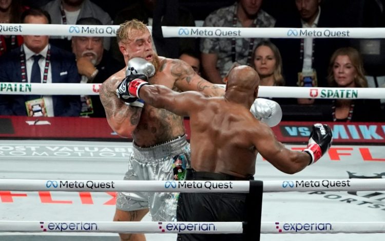 Jake Paul (left) backs Mike Tyson onto the ropes in their eight-round fight in Texas on Friday. ©AFP