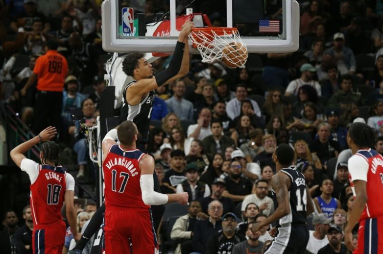 Victor Wembanyama of the San Antonio Spurs dunks past Jonas Valanciunas of the Washington Wizards on his way to the fastest 50 point performance in NBA history on Wednesday.. ©AFP