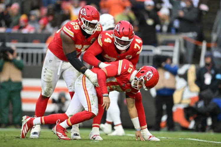 Kansas City Chiefs quarterback Patrick Mahomes is helped to his feet after a heavy hit in Sunday's win over Cleveland. ©AFP