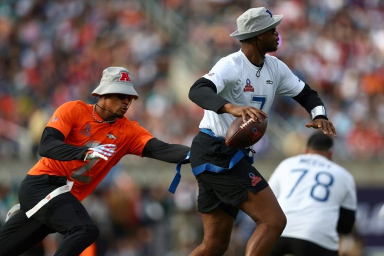 Pat Surtain of the Denver Broncos tries to grab the flag of Geno Smith of the Seattle Seahawks  at the 2024 NFL Pro Bowl Games. ©AFP